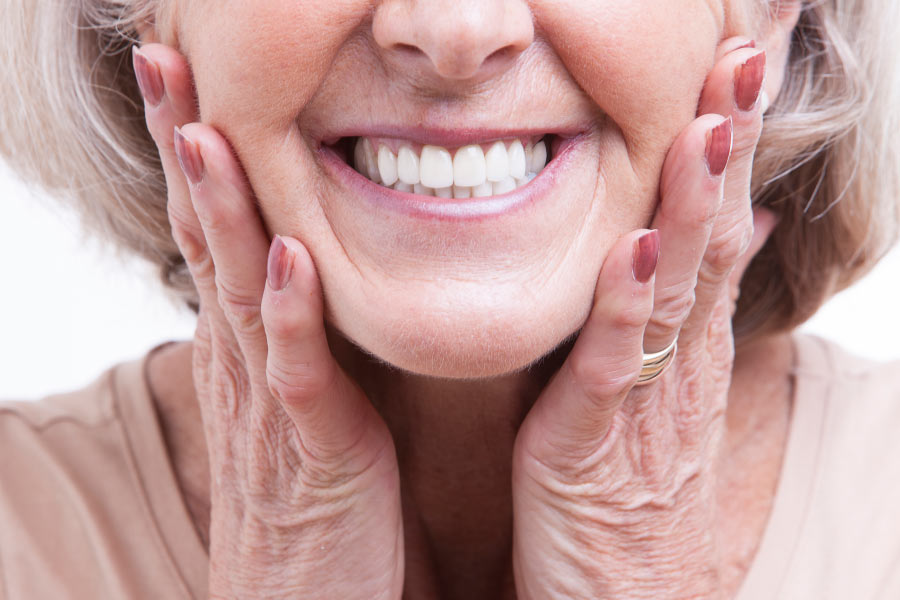 A close-up smile of a mature woman with dental veneers.