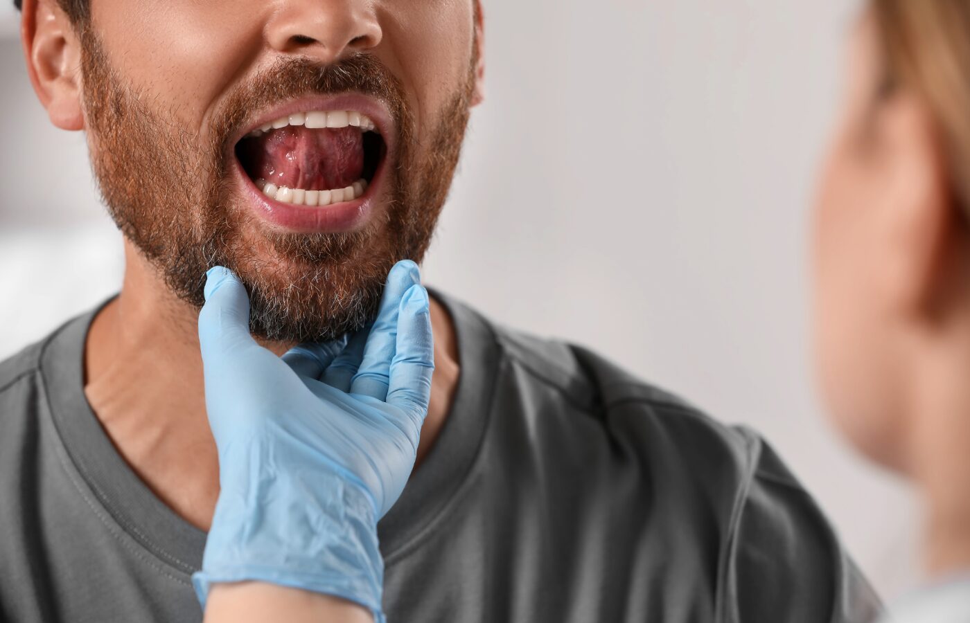 A man with a beard works with a myofunctinal therapist to address orofacial muscle deficiencies