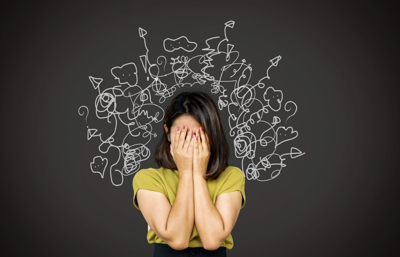 woman in green shirt in front of black screen with squiggles of stress radiating everywhere