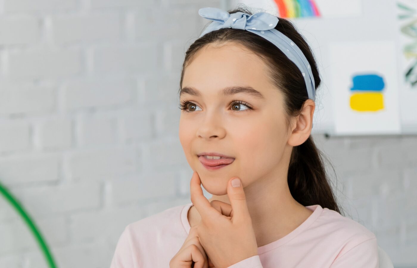 young girl holding neck as she does myofunctional therapy for tongue thrust